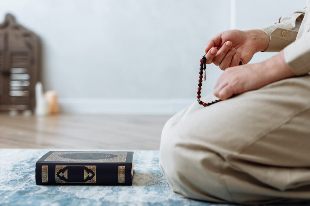 person holding prayer beads