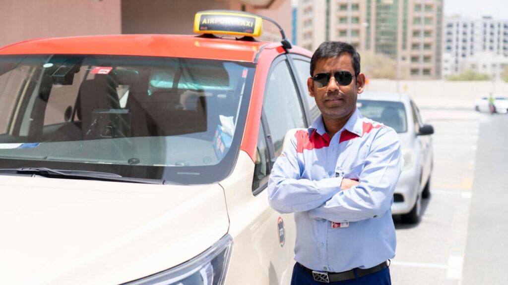 Driver job in Dubai, A Driver posing in front of his car.